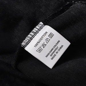 Detail shot of cotton t-shirt wash care label with text instructions and origin info.