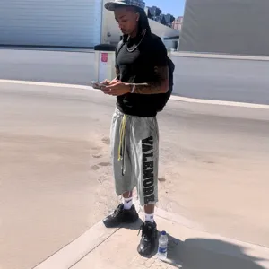 Shorts de loisir délavés streetwear unisexe avec impression de lettres et bords bruts.
