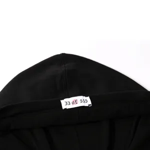 Close up of black hoodie collar detail with limited edition numbering label print.