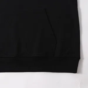 Close-up detail of black hoodie pocket and ribbed hem, casual streetwear apparel.