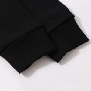 Close-up detail of black hoodie ribbed cuffs, showing fine texture and elastic knit design.