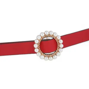 Close-up detail of women's red PU leather thin belt featuring an elegant round pearl buckle.