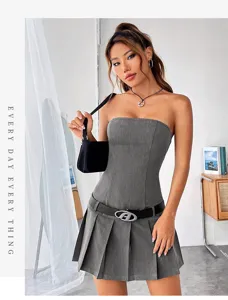 Grijs strapless mini-jurkje met een zilveren gespriem en een stijlvolle zwarte tas.