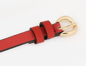 Detailaufnahme des roten Ledergürtels mit eleganter goldfarbener Metallschnalle und zwei Schlaufen.