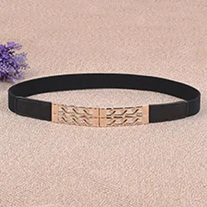 Detail shot of stylish black elastic waist belt with gold metal wave buckle for women dress.