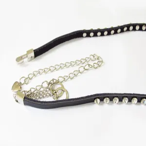 Detail view of a women's black leather rhinestone belt and metal waist chain accessory.