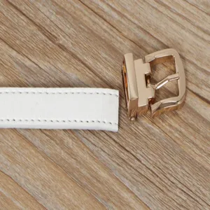 Close-up detail of white women's thin belt with elegant gold pin metal buckle design.