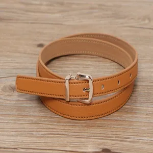 Detailed close-up of a stylish brown women leather belt with a delicate metal pin buckle.