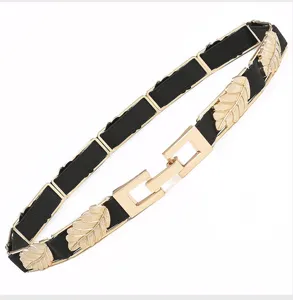 Detailed view of women fashion elastic waist belt with gold leaf metal buckle dress accessory.