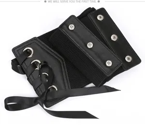 Dettaglio di cintura corsetto nera e larga con lacci in nastro, occhielli metallici e bottoni.
