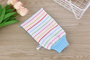 Close-up of a colorful striped exfoliating bath mitt with blue ribbed cuff on wooden surface.