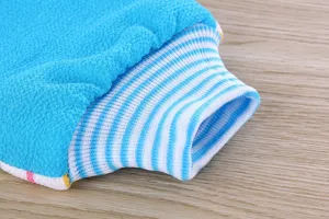 Exfoliating bath mitt detail showing textured blue surface and striped elastic cuff.