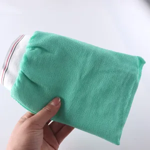 Vista detallada del guante de baño exfoliante con tela verde texturizada y elástico.