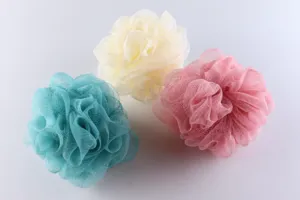Detailed shot of colorful mesh bath sponges in cyan, beige and pink, soft PE material scrubber.