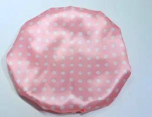 Dettaglio cuffia doccia a pois rosa con tessuto satinato impermeabile ed elastico.