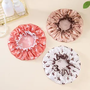 Waterproof double layer satin shower cap with cute bow print for hair care and bathing styling.