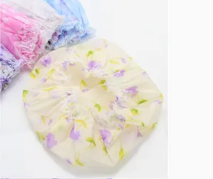 Waterproof shower cap detail showcasing floral print, lace trim and elastic gathered edge.