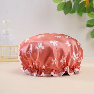 Detail shot of waterproof satin shower cap with cute white bow print and ruffled hem design.
