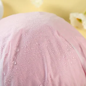 Wasserdichte Duschhaube Detailansicht, rosa doppellagige Badekappe mit Wassertropfen.
