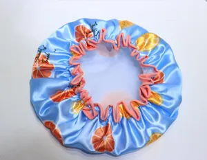 Cuffia doccia impermeabile in raso blu con stampa arancia e volant rosa per protezione.