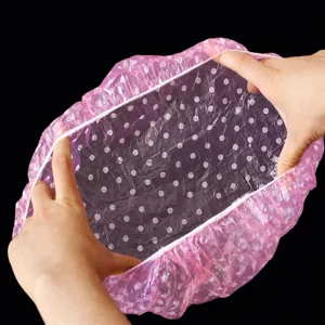 Disposable pink dot shower cap for daily use, waterproof elastic bath cap for hair protection.