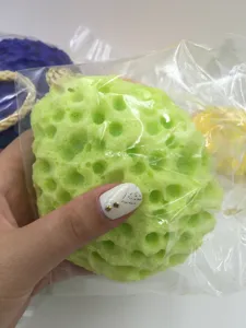 Green honeycomb wood pulp sponge detail shot, soft texture for body bath and cleaning.