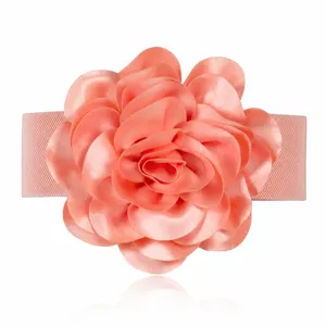 Détail de ceinture élastique large décorative avec grande fleur en tissu rose pour robe