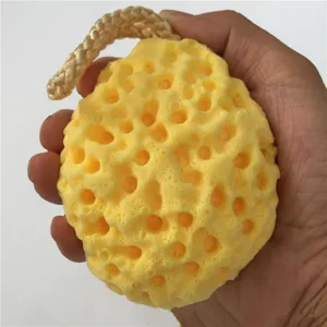 Yellow honeycomb wood pulp sponge for bath and body cleaning, soft texture detail view.