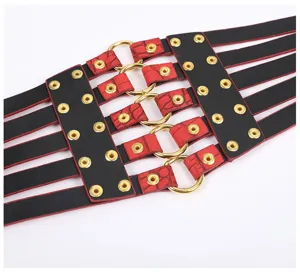 Detailed shot of wide black and red waist belt featuring metal rings and eyelet studs.