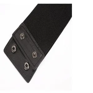 Close-up detail of black elastic wide waist belt with crocodile pattern PU leather and metal snap.