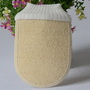 Dettaglio primo piano di un guanto da bagno in luffa naturale con polsino in maglia per peeling.