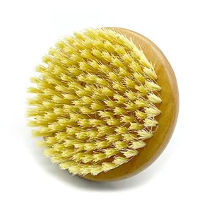 Vue détaillée de la brosse corporelle ronde en bois avec des poils naturels de sisal pour gommage.