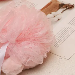 Grande spugna da bagno in rete rosa con laccetto e palla di peluche per una doccia delicata.