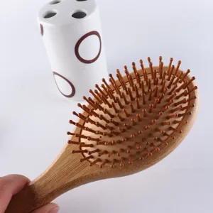 Spazzola per capelli in legno con perni in bambù per massaggio del cuoio capelluto.
