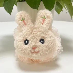 Primo piano di una graziosa spugna da bagno in peluche con gonna a rete e ricamo di carote.