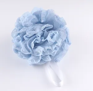 Close-up detail of a soft light blue lace mesh bath sponge with white hanging ribbon.