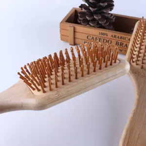 Primo piano dettagliato di spazzola per capelli in bambù con perni in legno e base ad aria.