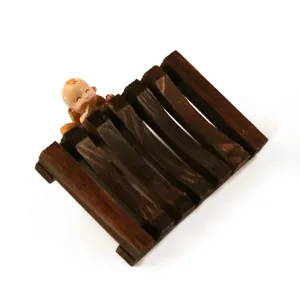 Wooden soap dish detail view featuring natural wood texture and cute figurine decoration.