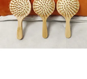 Natural bamboo air cushion hair brush with wooden pins, detail view showcasing three combs.