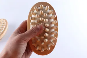 Wooden massage brush detail view showcasing natural wood texture and smooth rounded pins for comfortable daily care.