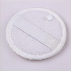 Detailed view of the white round natural plant fiber bath sponge with elastic hand strap.