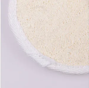 Natural loofah bath scrubber detail view, plant fiber exfoliating body pad with white edge.