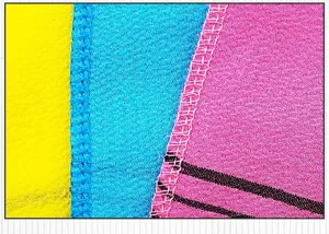 Dettaglio di panno esfoliante con tessuto strutturato e cucitura colorata resistente.