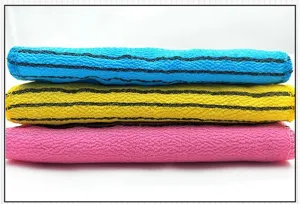 Primo piano dettagliato di tre asciugamani da bagno esfolianti colorati e impilati in modo ordinato.