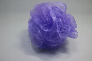 Close up of a soft purple mesh bath sponge detail showing fluffy textured loofah surface.