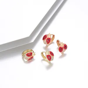 Orecchini a cerchio dorati a forma di coccinella con smalto rosso e zirconi luminosi.