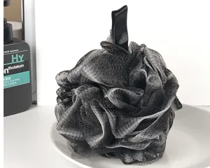 Vista dettagliata della grande spugna da bagno nera in rete, soffice pouf doccia per il corpo.