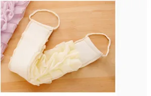 Brosse exfoliante pour le dos avec filet souple et double poignée pour un nettoyage facile.