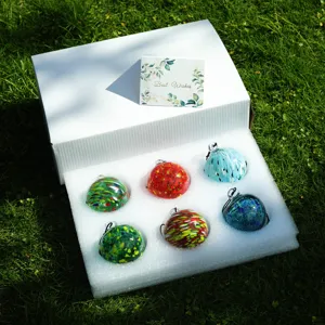 Detailed view of colorful blown glass suncatcher decorative balls neatly arranged in gift box.