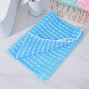 Primer plano detallado de toalla de baño exfoliante azul de nylon con patrón jacquard doblada.